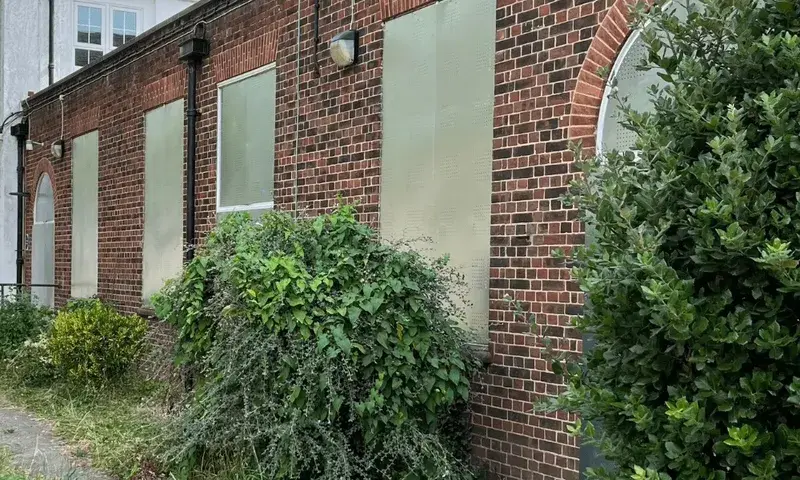 Steel security screens installed on windows of a vacant property to prevent break-ins and vandalism.