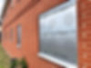 Vacant red-brick building secured with steel security screens installed over the windows to prevent break-ins and vandalism