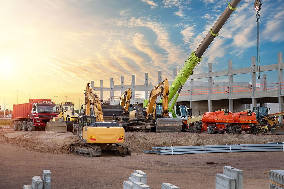 Construction site with heavy machinery, excavators and cranes at sunset. Potential security risk area requiring temporary fencing and CCTV monitoring