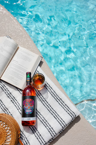 bottle of wine laying beside a pool