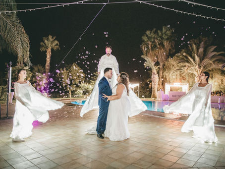 Paola e Vincenzo durante il loro matrimonio al Casale Conzoli, mentre danzano all’aperto tra luci, palme e atmosfera romantica.