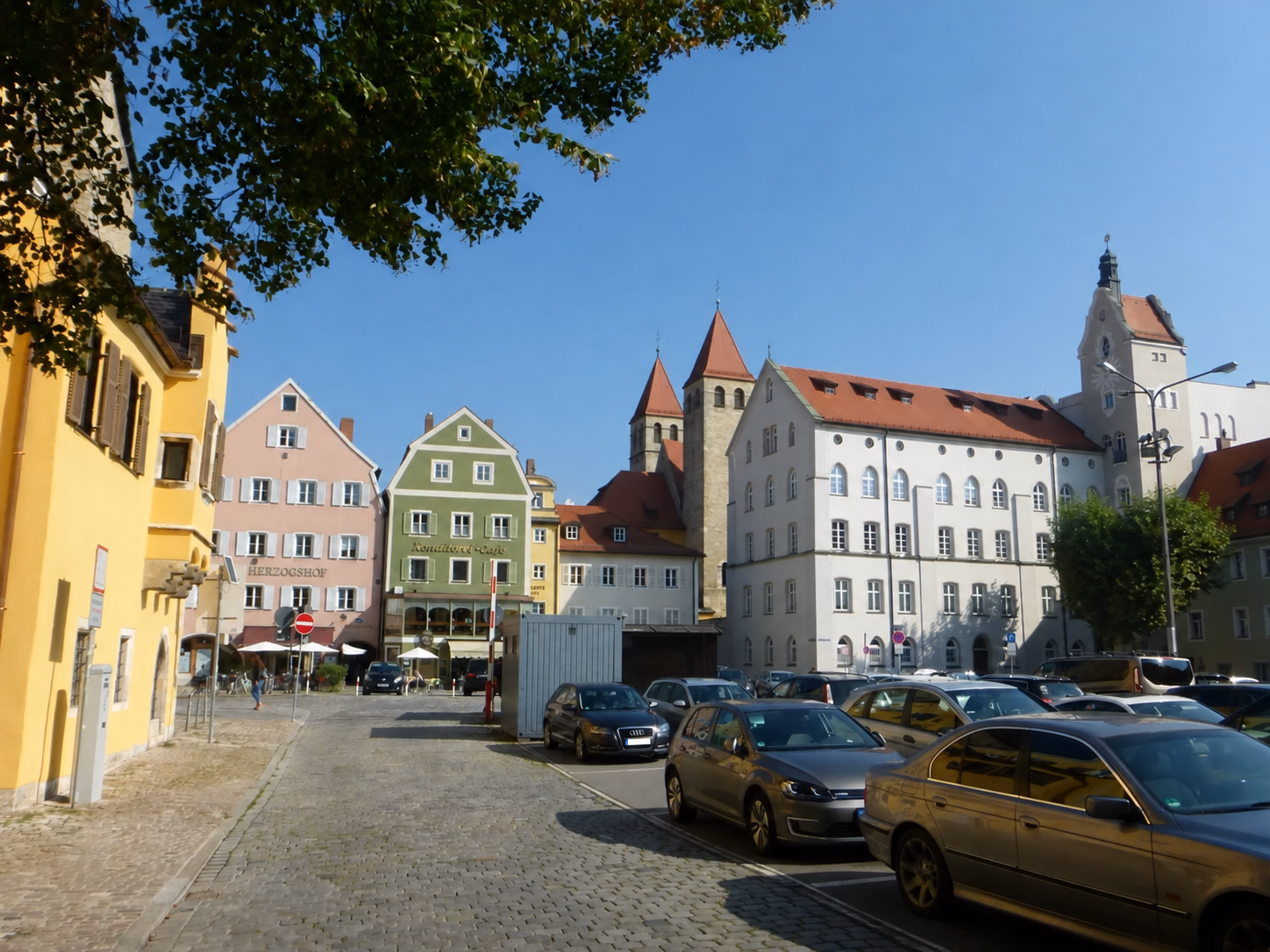 Colorful historic buildings and parked cars in Regensburg Old Town