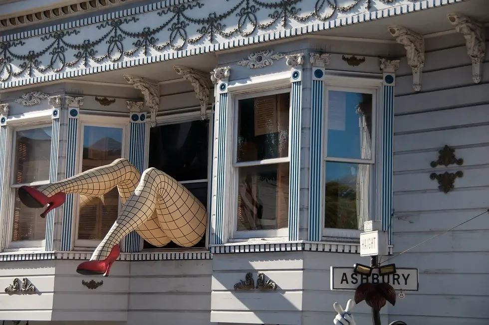Ornate Victorian house in Haight-Ashbury, with decorative legs extending from an upstairs window.