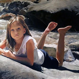 Young girl lying on a large rock in a clear mountain stream.