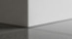 Architectural detail. A wall meeting a floor with no baseboard, just a floating shadow reveal (fry reglet). Seamless plaster to stone.