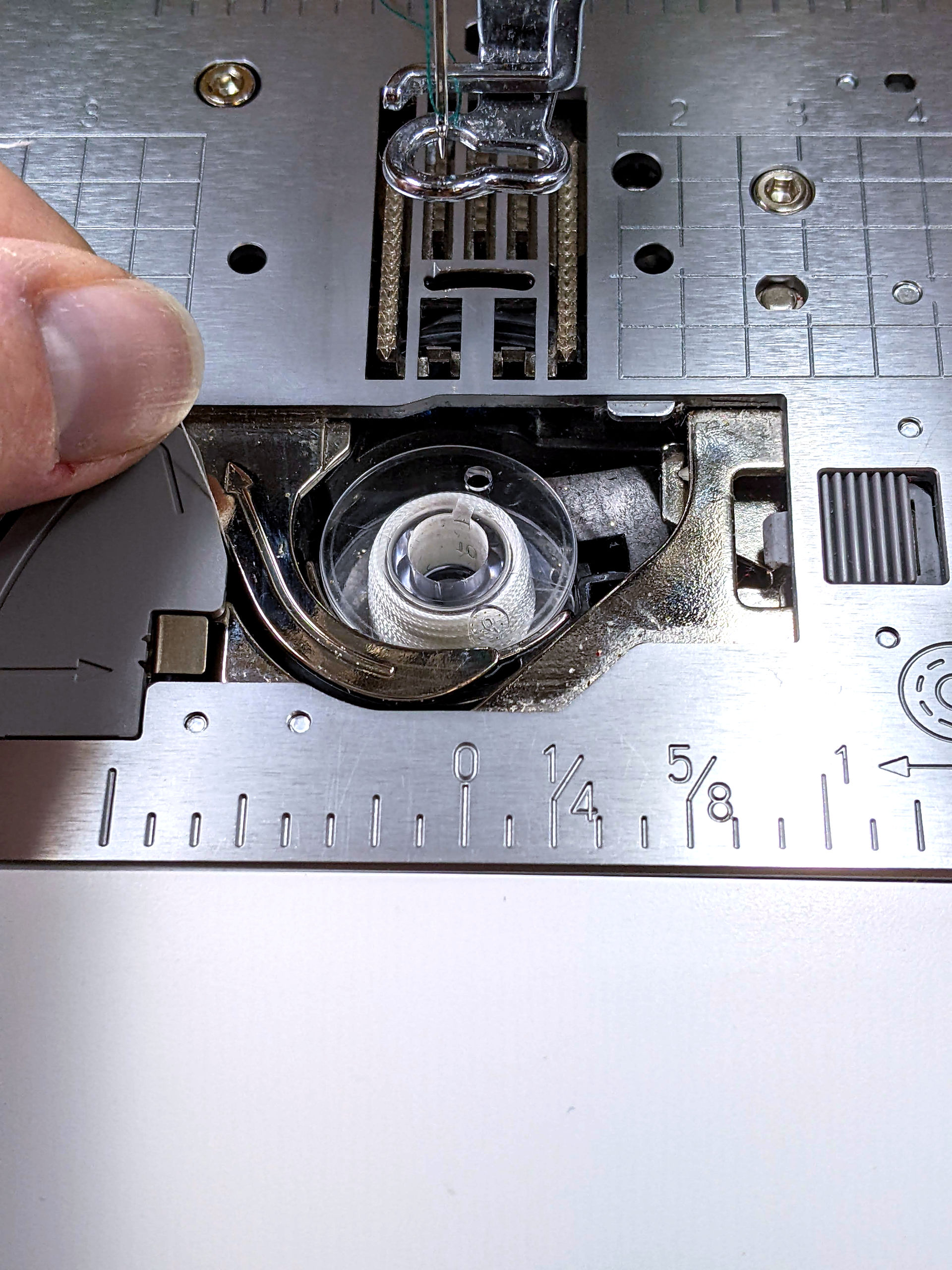 Threading the bobbin on a top loading embroidery machine