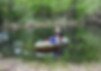 student in boat on pond