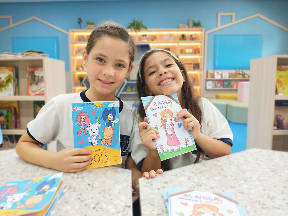 Duas meninas segurando livro na biblioteca do Diocesano