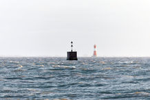 Foto | Bild: Das "Krüger-Denkmal" mit Nord-Kardinalbake und im Hintergrund der Leuchtturm Arngast im Jadebusen.
Format: JPG | 6343 x 4229 px