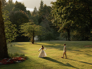 Bride and groom Allie and Sam share a romantic golden-hour moment on a sunlit lawn at Bridal Veil Lakes in Oregon's Columbia River Gorge, during their woodland wedding coordinated by Your Perfect Bridesmaid, an Oregon wedding planning and coordination company.