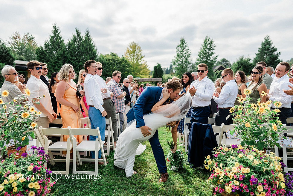 Bride and groom kissing during an outdoor summer wedding ceremony at Pine Creek Farm and Nursery, a garden wedding venue in Washington.