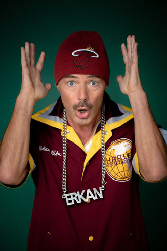 Erkan mit roter Mütze, "ERKAN" Kette, "HBSSV" Shirt, Hände oben.