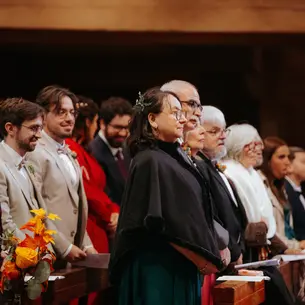 Groupe de proches écoutant attentivement une cérémonie de mariage, capturés sur le vif lors d’un reportage photo naturel et émotionnel.