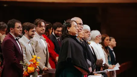 Groupe de proches écoutant attentivement une cérémonie de mariage, capturés sur le vif lors d’un reportage photo naturel et émotionnel.