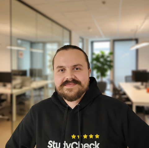 Nils, Fullstack Entwickler bei StudyCheck Köln, fokussiertes Portrait eines Mannes im Tech-Arbeitsumfeld