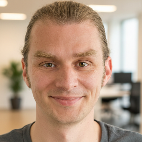 Simon, Lead Developer bei StudyCheck Köln, konzentriertes Portrait eines Mannes im modernen Tech-Umfeld