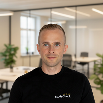 Paul, Teamlead Marketing bei StudyCheck Köln, professionelles Portrait eines Mannes im modernen Büro