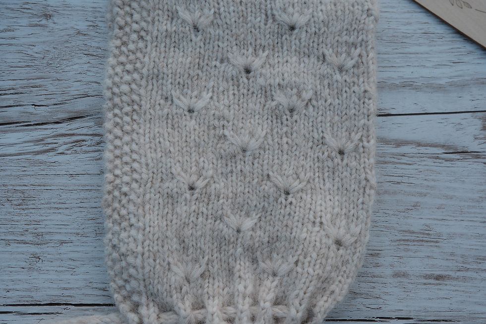 Detail des Strukturmusters der handgestrickten Kindermütze Wiesenblume