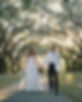 Newlyweds stroll under moss-draped oaks, enjoying a stress-free celebration with our Charleston wedding packages.