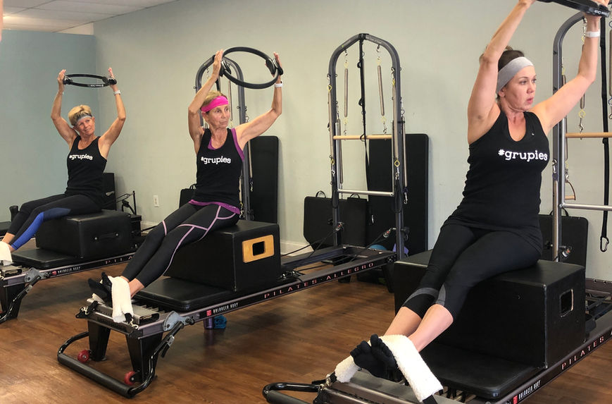 group pilates class using pilates ring and tower