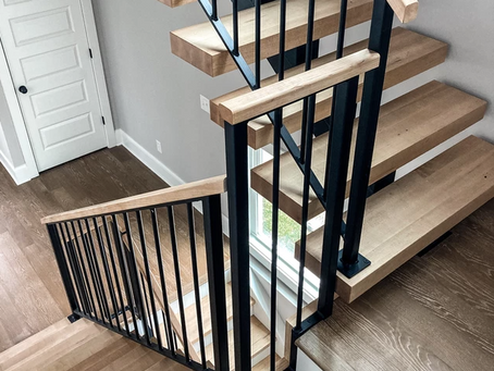 Custom floating staircase with thick solid hardwood treads and welded steel railing system