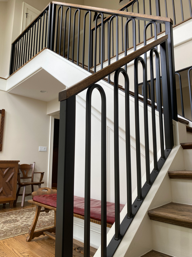 Decorative steel railing with arched balusters on a residential staircase