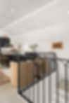 Custom welded steel railing surrounding a staircase landing in a modern residential interior