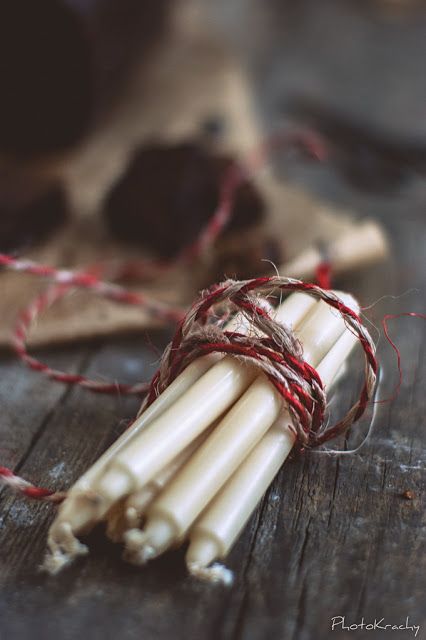 bougies blanches attachées avec un cordon blanc et rouge