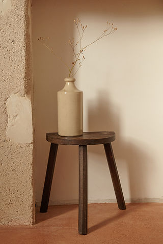 bouteille en grès sur un tabouret en bois vintage au château de la haute borde