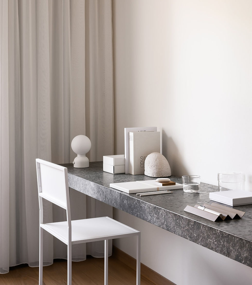 chaise blanche devant un bureau gris remplis d'objets blancs