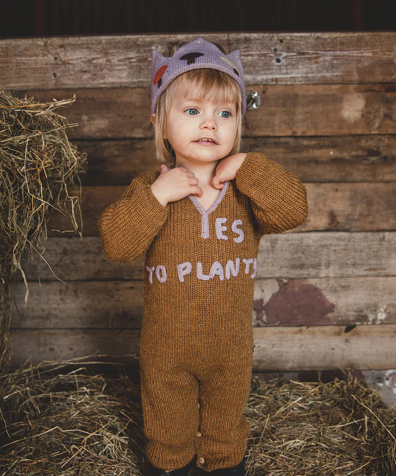 enfant dans une grange portant une combinaison en laie Yes to Plants
