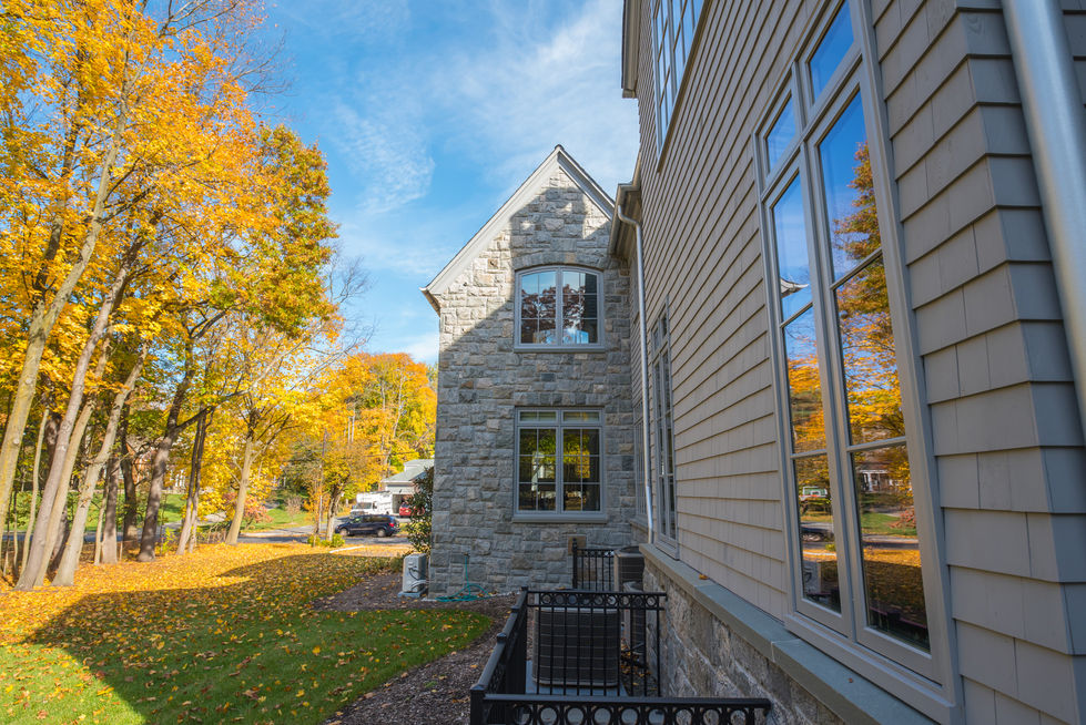 Stone house with autumn trees and blue sky.