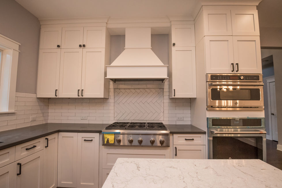 Modern kitchen with white cabinets and stainless steel appliances.