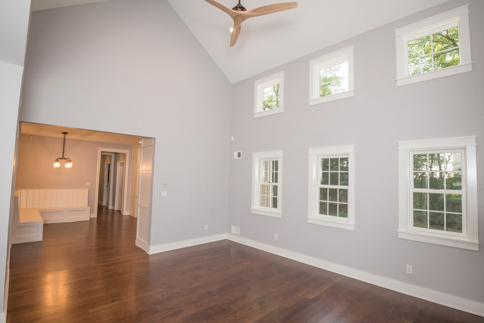 Spacious room with high ceiling and multiple windows.