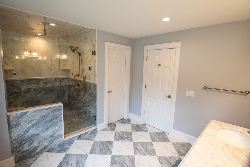 Bathroom with checkered floor and glass shower enclosure.