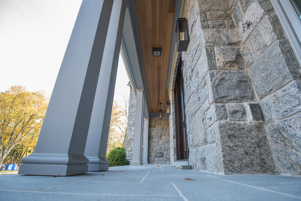 Stone house facade with columns and lanterns.