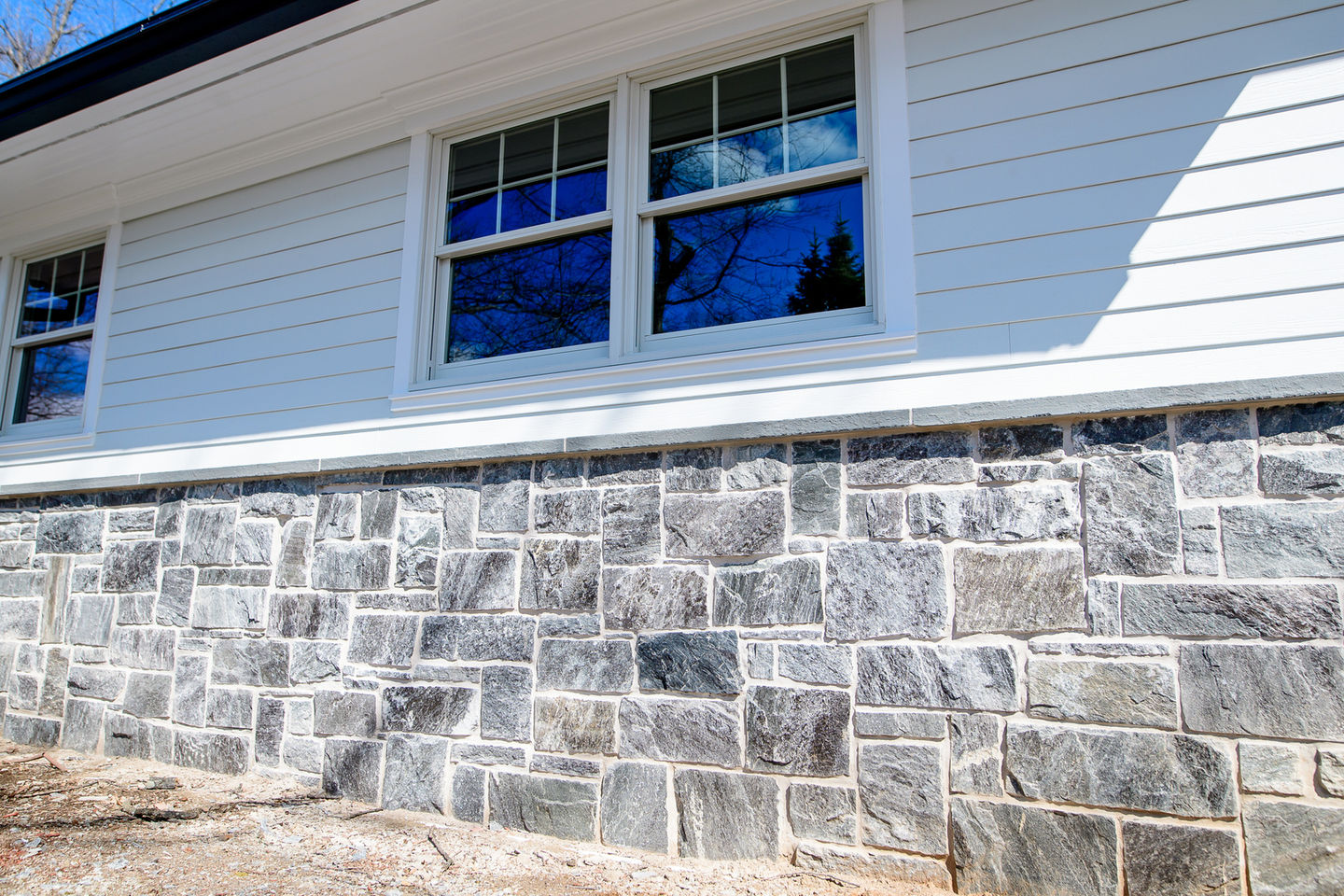 House window with stone and siding exterior.