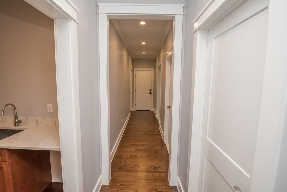 Hallway with wooden floor and white doors.