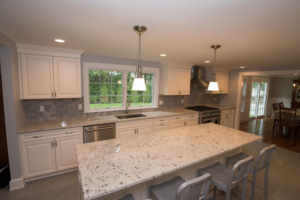 Modern kitchen with large island and pendant lights.
