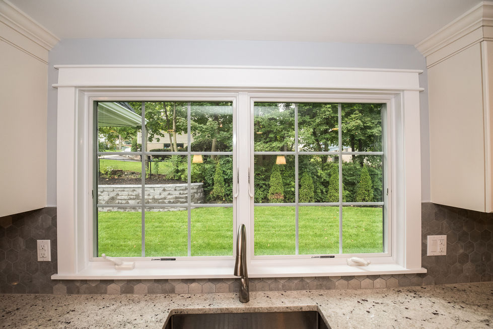 View through kitchen window to green backyard.