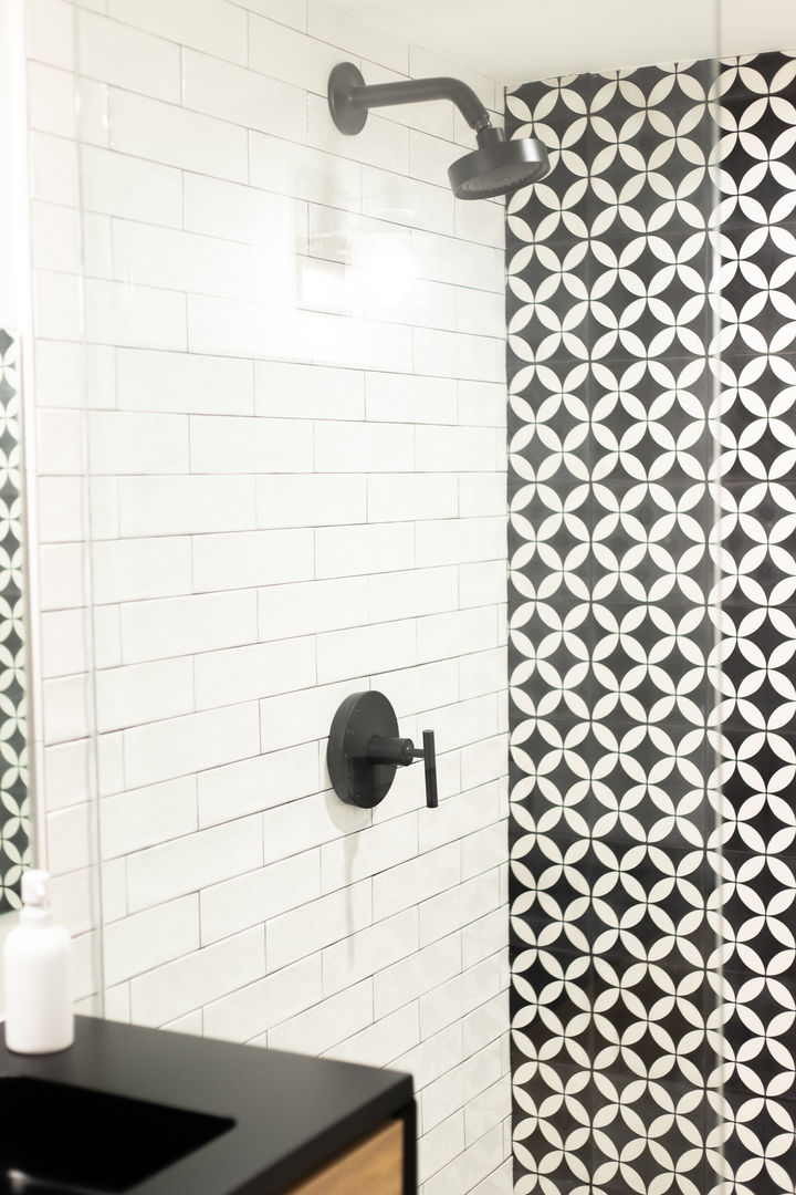 Black and white patterned shower tiles with white subway tiles.