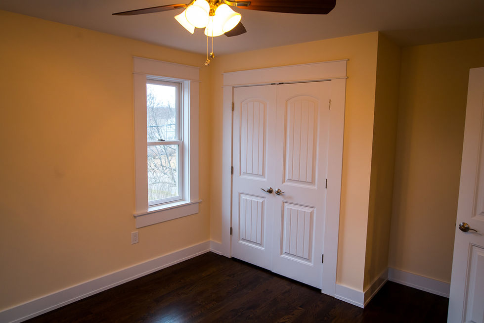 Bedroom in Ridgewood, NJ with new hardwood floors, double-door closet, and modern lighting