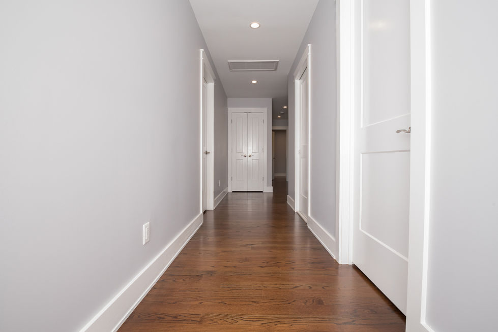 Hallway with wooden floor and white doors.