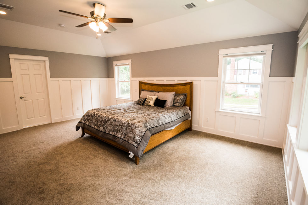 Bedroom with wooden bed and ceiling fan.