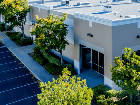 Commercial condo association building exterior with landscaping and shared parking