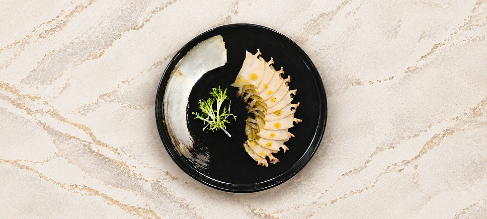 Kansom Australian Wild Blacklip Abalone sashimi-style slices arranged on a black plate over a light marble background.