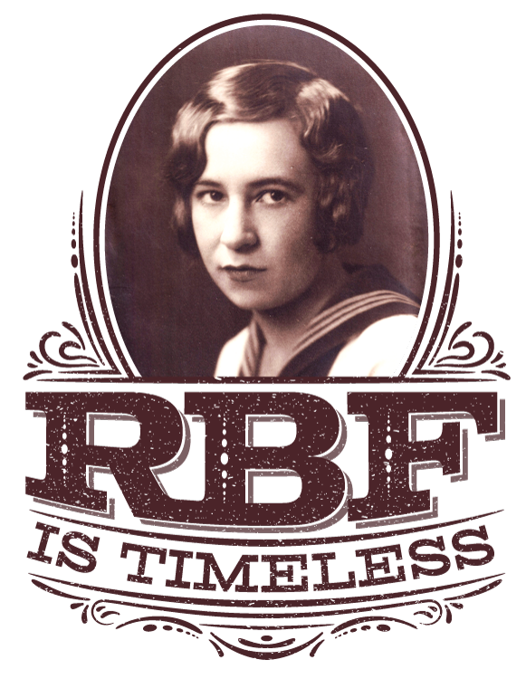 Thumbnail: A magnified view of t-shirt front with a vintage style graphic with portrait artwork that reads “RBF is timeless.