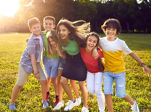Group of happy cheerful active little children enjoying summer break, meeting in park, fro
