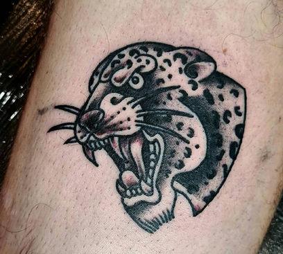 A tradtional leopard heal tattoo with black lines and shading