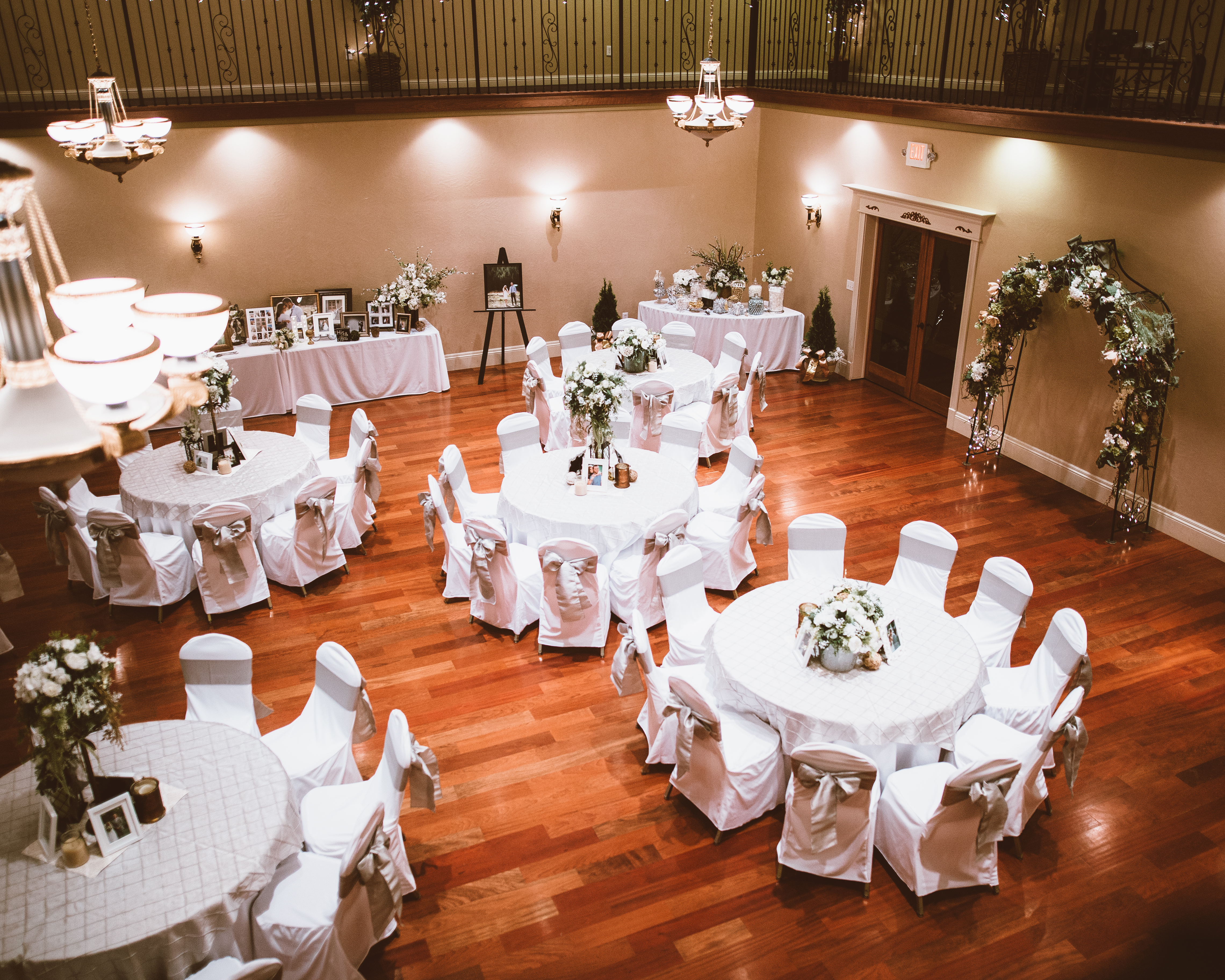 The ballroom set with round tables, floor-length linens, and chair covers.